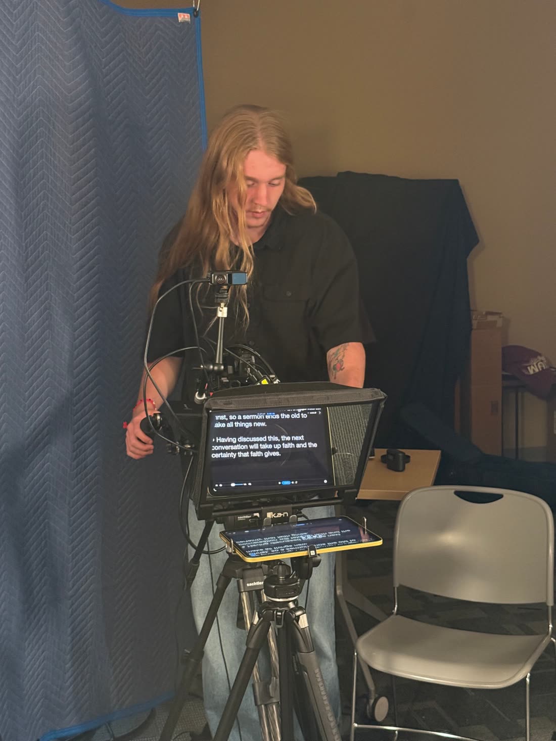 Fuller setting up a camera and teleprompter on a shoot